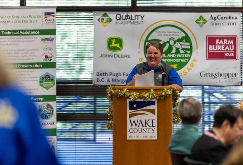 smiling speaker stands at podium