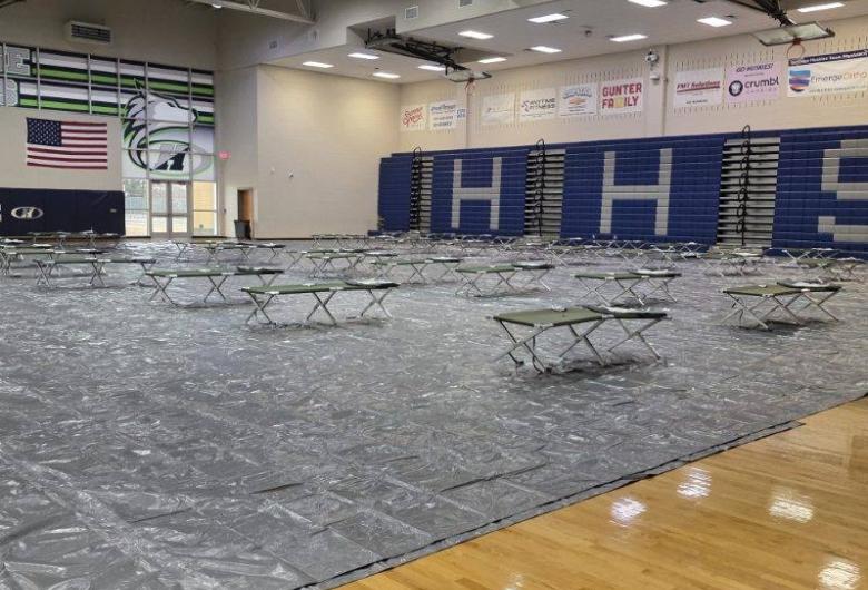 shelter inside Heritage High School gym, with cots