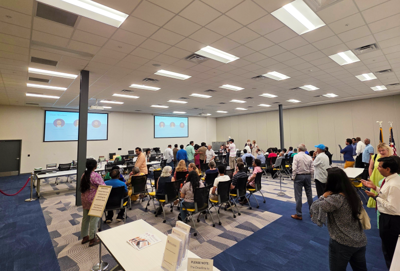 People gathered in a room at a presentation and signup.