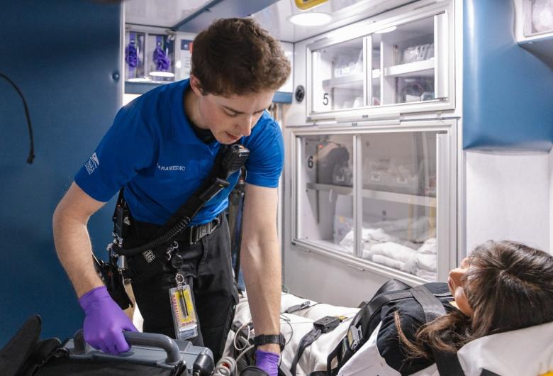 Paramedic treats a patient inside an ambulance.