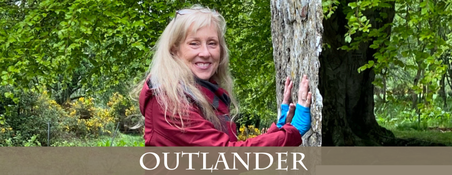 Presenter Dawn Woo leaning against a standing stone in Scotland