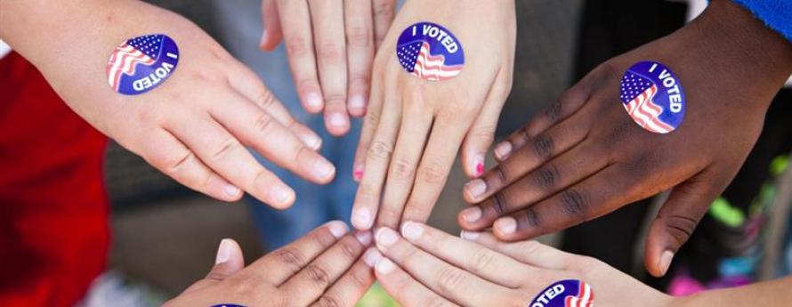 hands with voting stickers