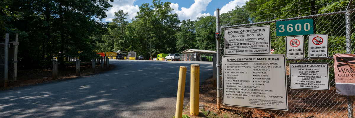 entrance to convenience center driveway, with vehicles parked inside