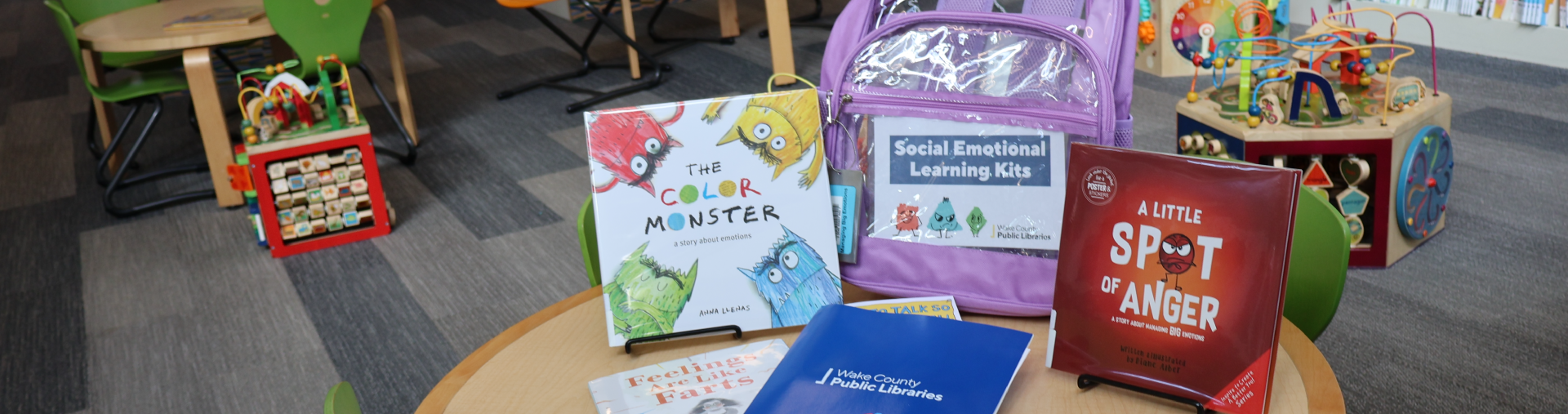 Books, folder and activity supplies on a table in the library