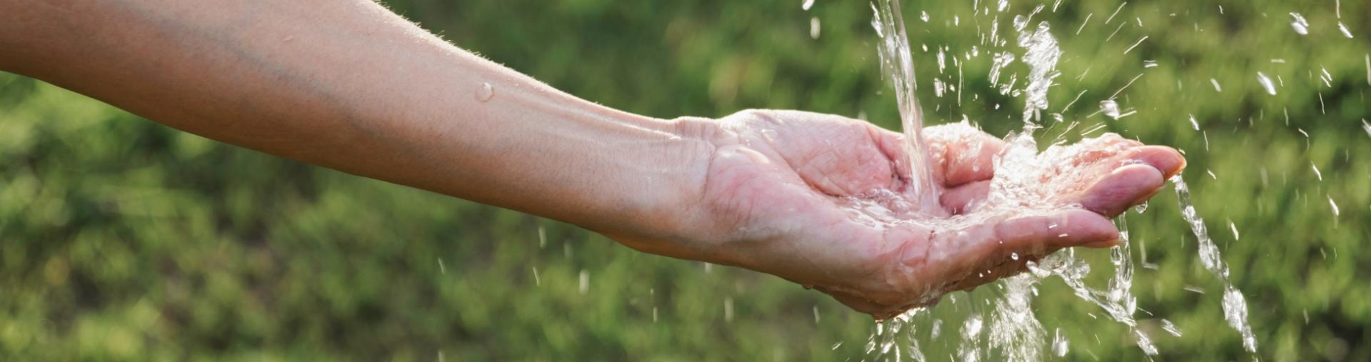 Water pours into an open hand.
