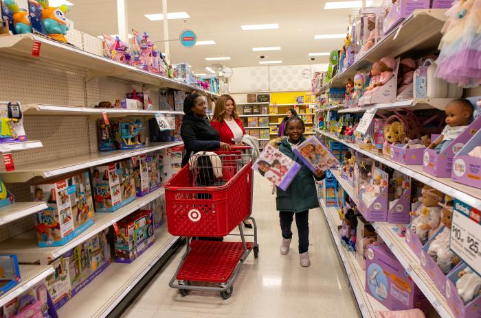 A WCSO employee, a woman, and a child smiling standing in an aisle in Target.
