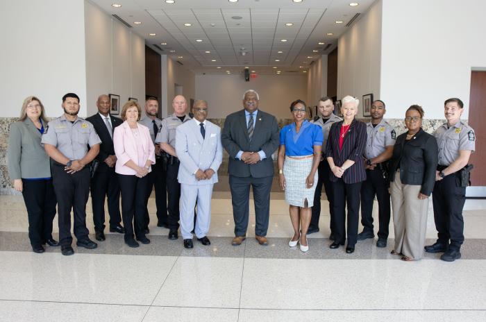 Sheriff Rowe, the Wake County Commissioners and the six deputies who helped the patient all stand together in a group smiling..