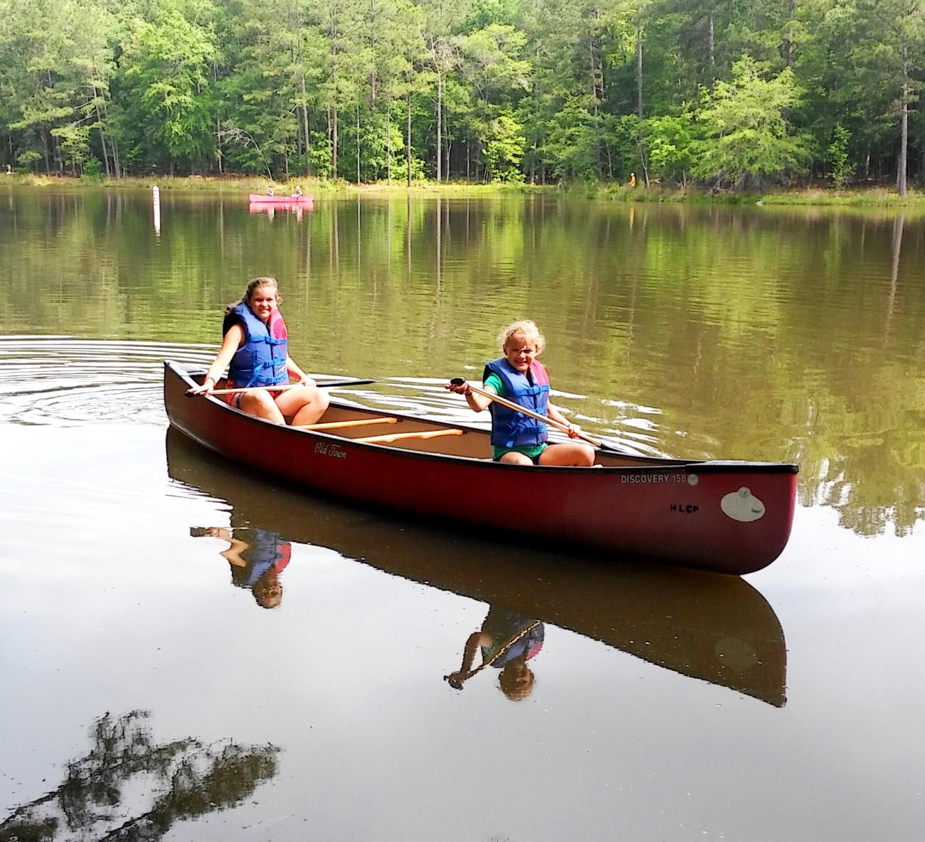 Photo of two campers in a canoe on the fishing pond