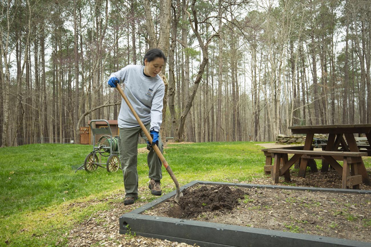 park employee working with shovel in garden