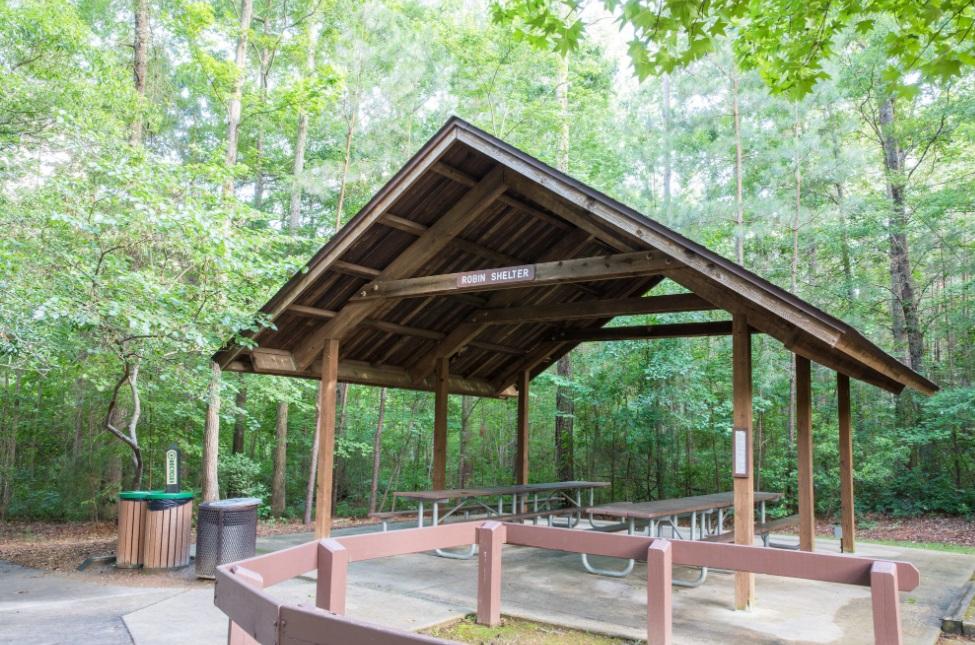 View of the parks smallest wooden picnic shelter with picnic tables