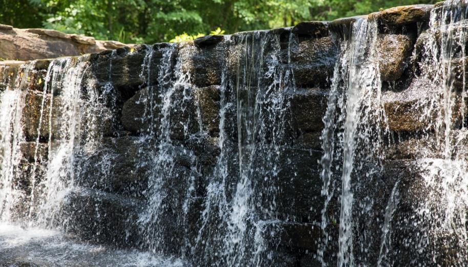 water flowing over stone mill dam