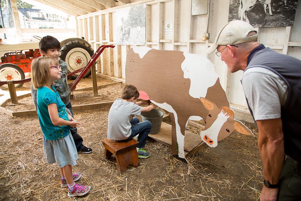 Kids in the barn using the milking interactive display