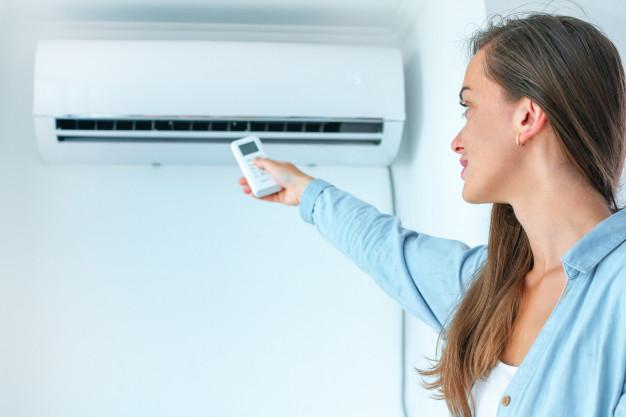 Woman controlling the air conditioner.