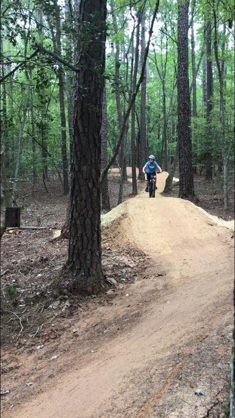 Photo of a person on a mountain bike using the Flow Trail found on the advanced section of the Hog Run mountain bike trail