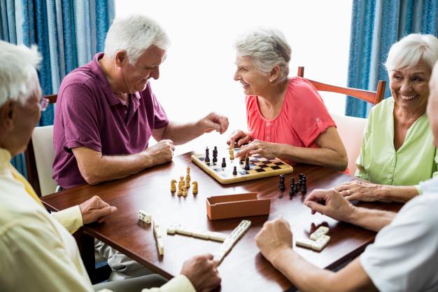 Senior citizens playing games at a table.