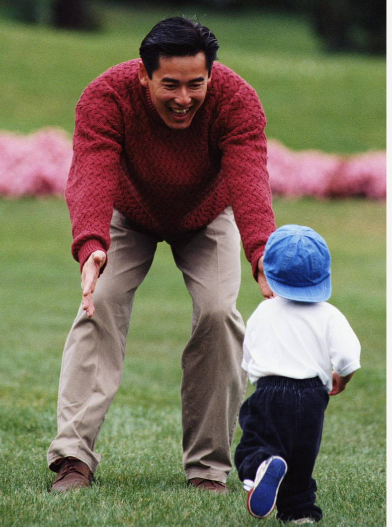 Son running to his father in the grass