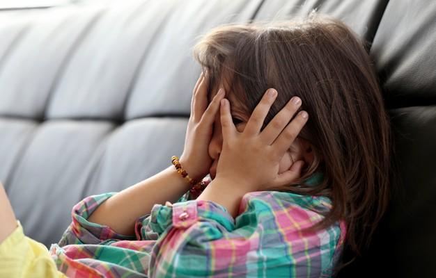 Young girl hiding her face