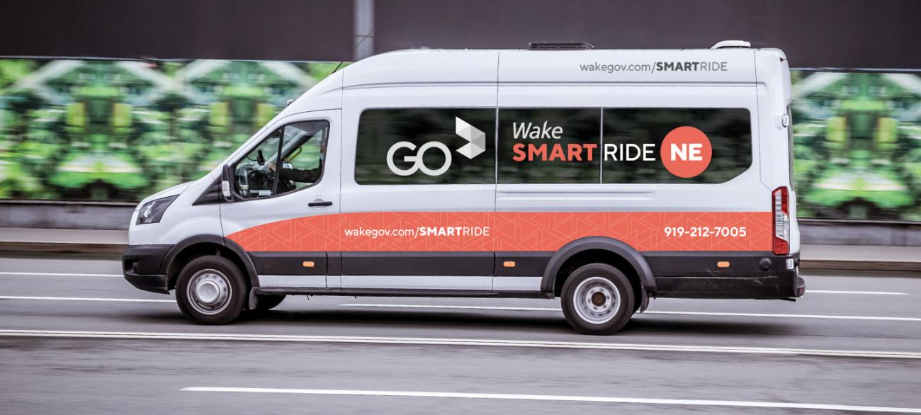 Wake SmartRide van drives down a city street.