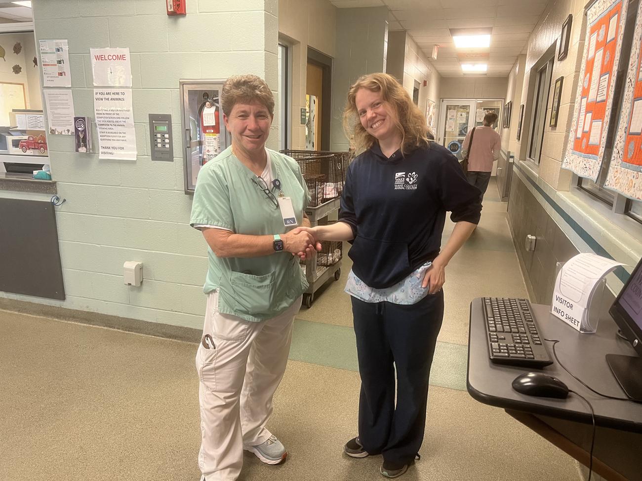 Julie Stolzer (left) shakes hands with Michelle Phillips-Pratt, Animal Services Receiving/Kennel Supervisor.