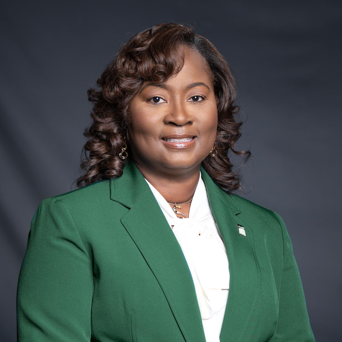 Chair Shinica Thomas photos in green suit smiling 