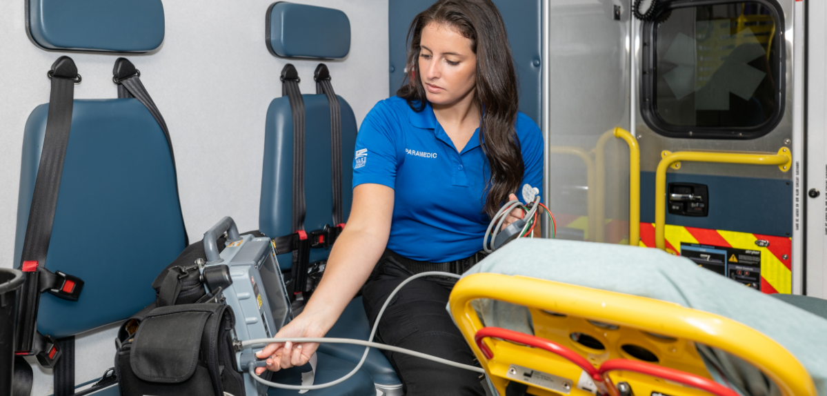 Paramedic working with equipment in emergency vehicle.