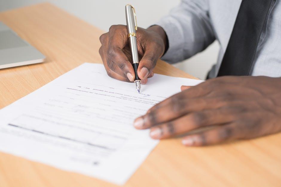 Person's hands with pen filling out form