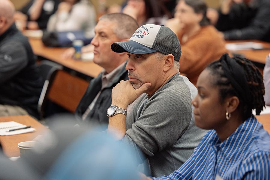 seated conference attendees listen to a presentation