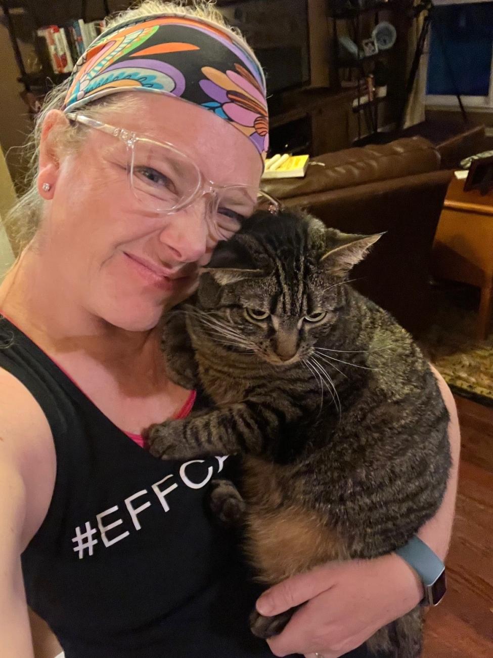 smiling woman cuddles with cat