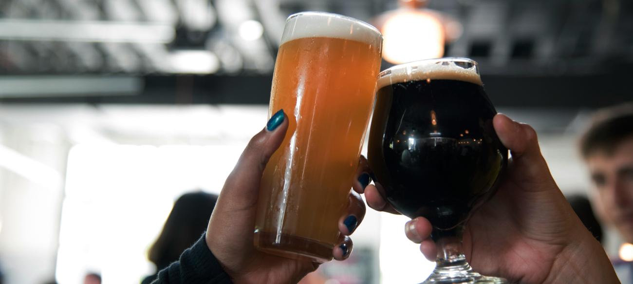 Two people clinking beer glasses 
