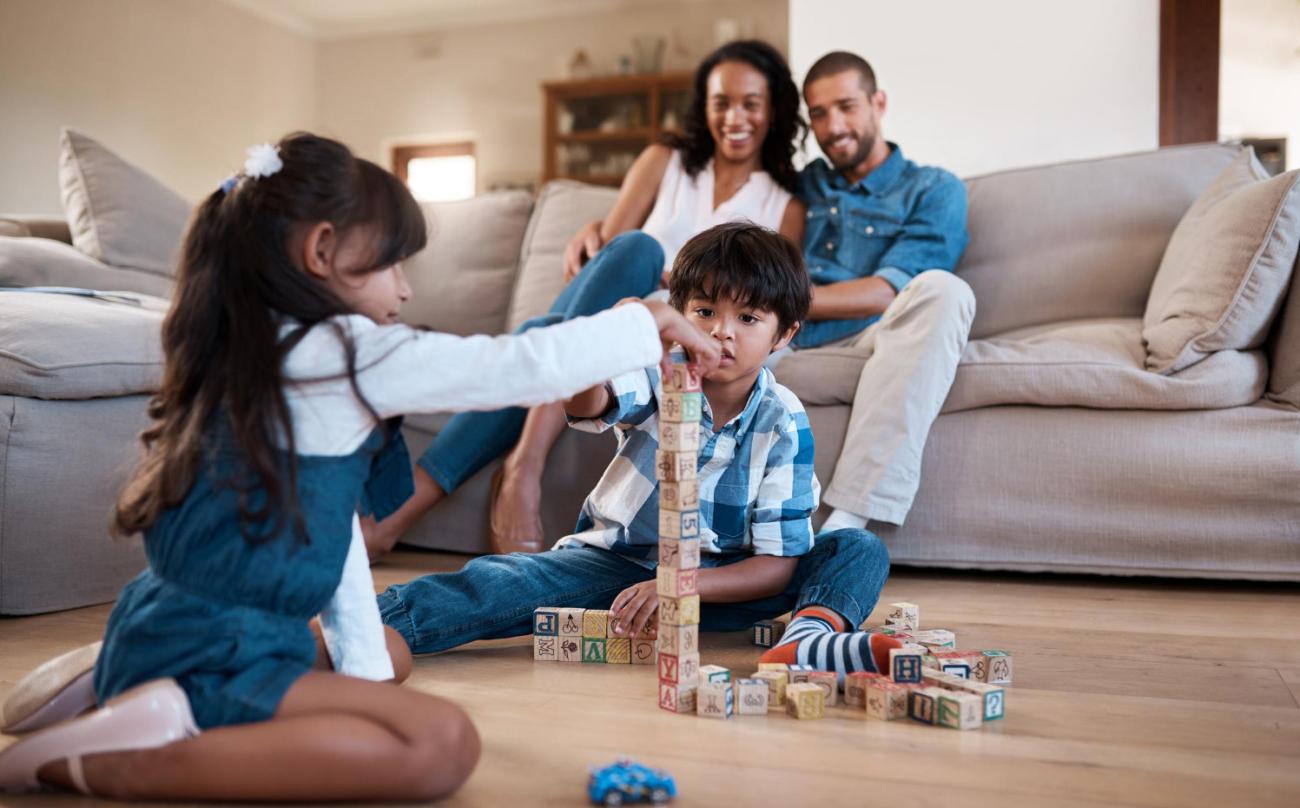 Parents watch as children play with building blocks