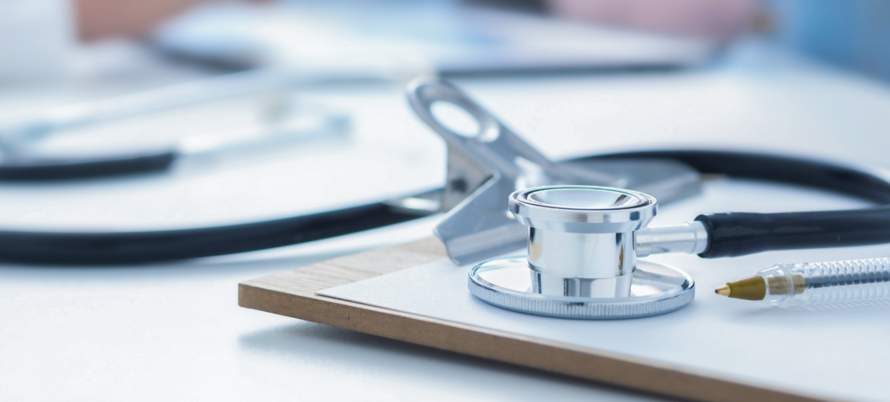 Stethoscope and clip board on the doctor workplace close up