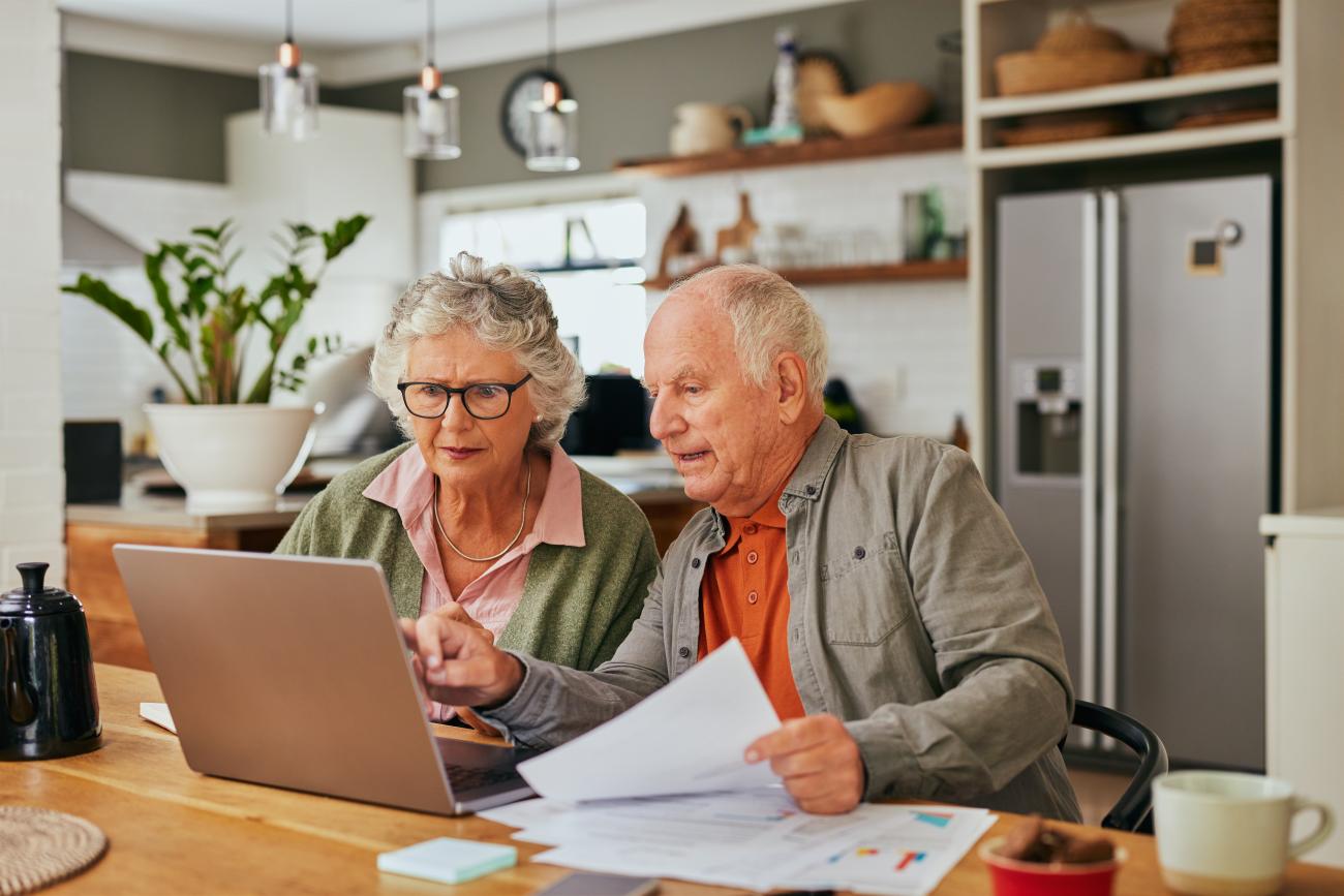elderly couple look at computer screen