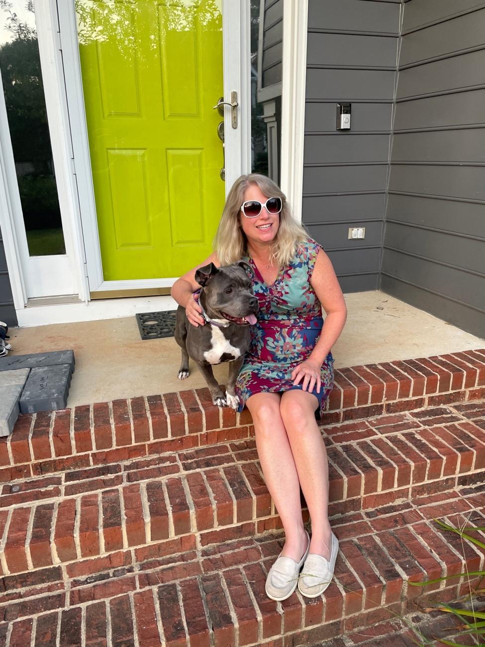woman sitting on steps hugs dog