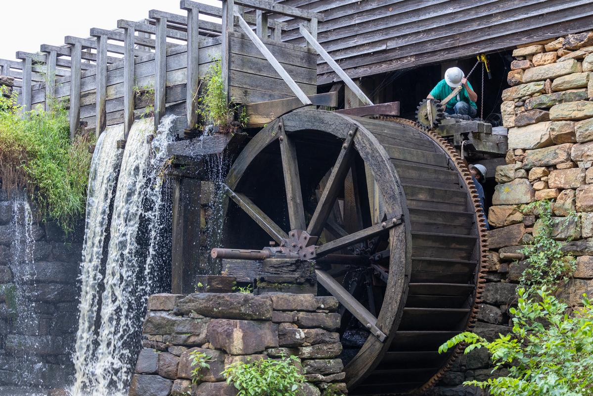 Millwright works on the waterwheel at Historic Yates Mill County Park