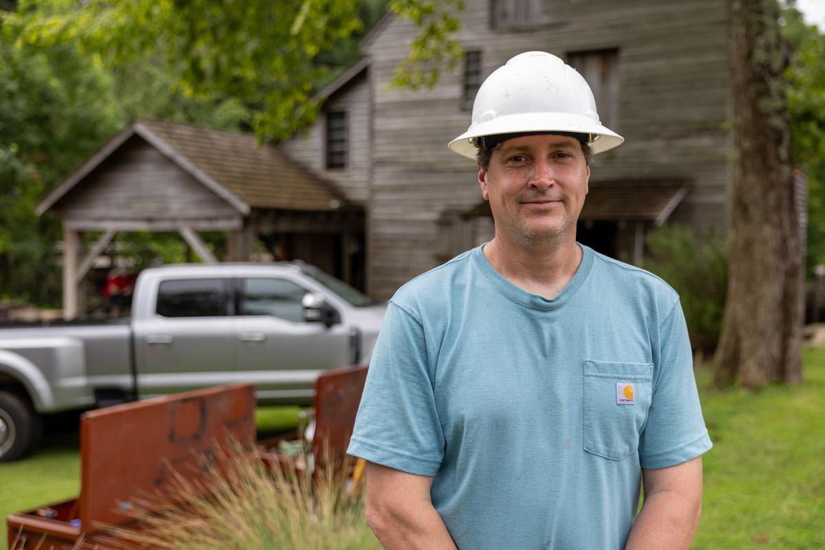 Millwright Ben Hassett poses in front of the mill