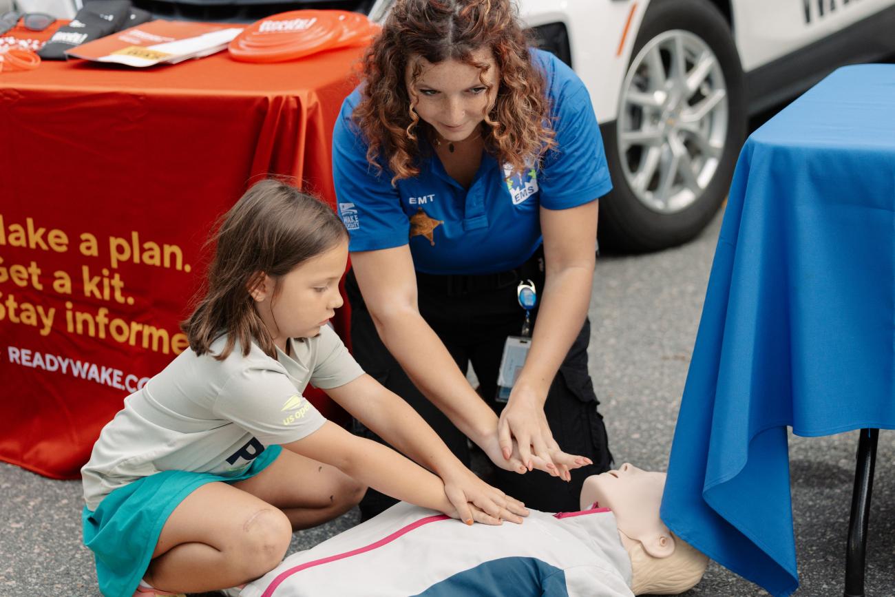 Wake EMS staff teaching CPR to a child