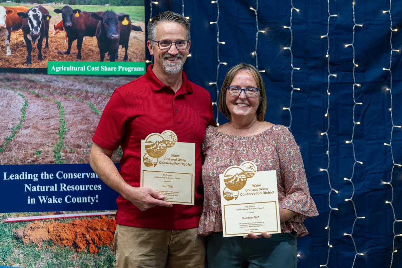 man and woman stand with awards