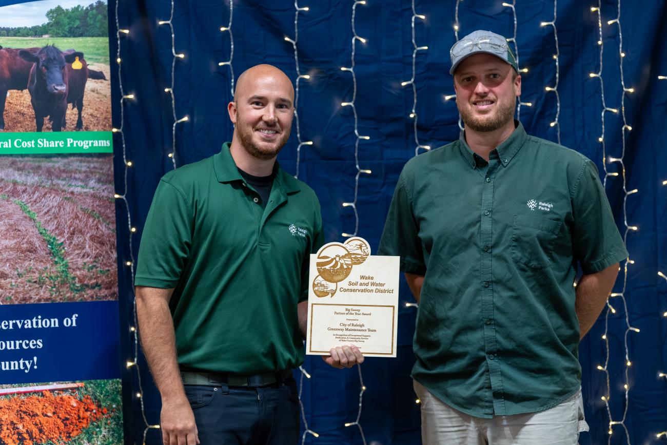 two men stand with award