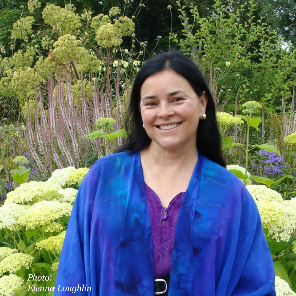 smiling woman standing in flower garden