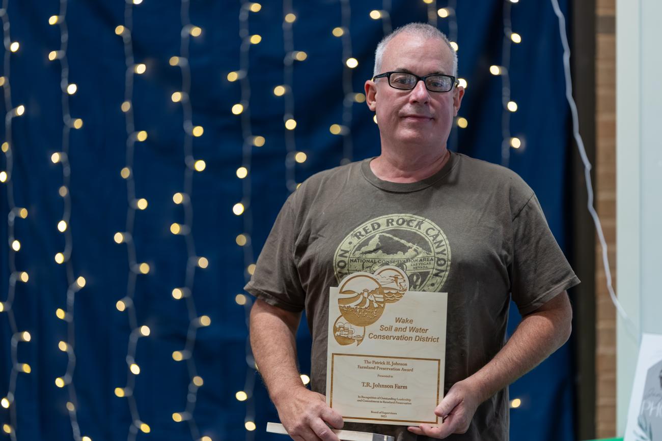 man stands with award
