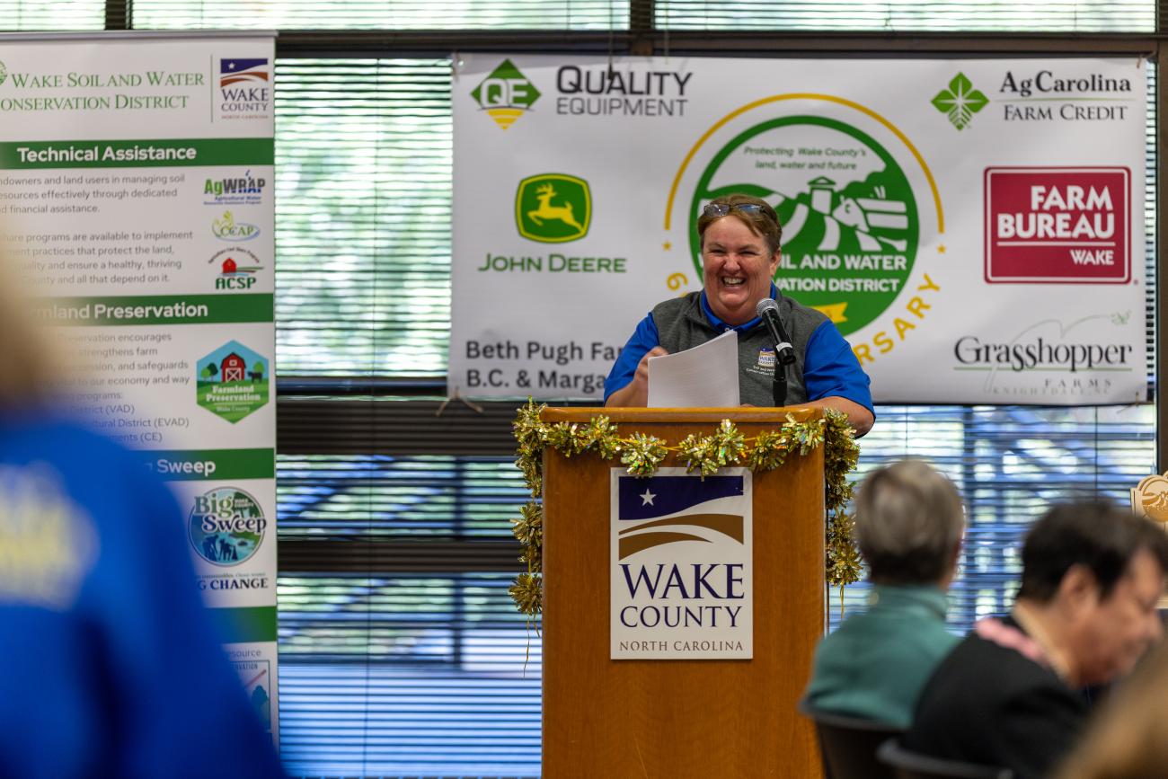 smiling speaker stands at podium