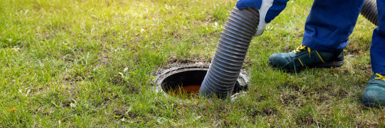 man pumping out house septic tank. drain and sewage cleaning service