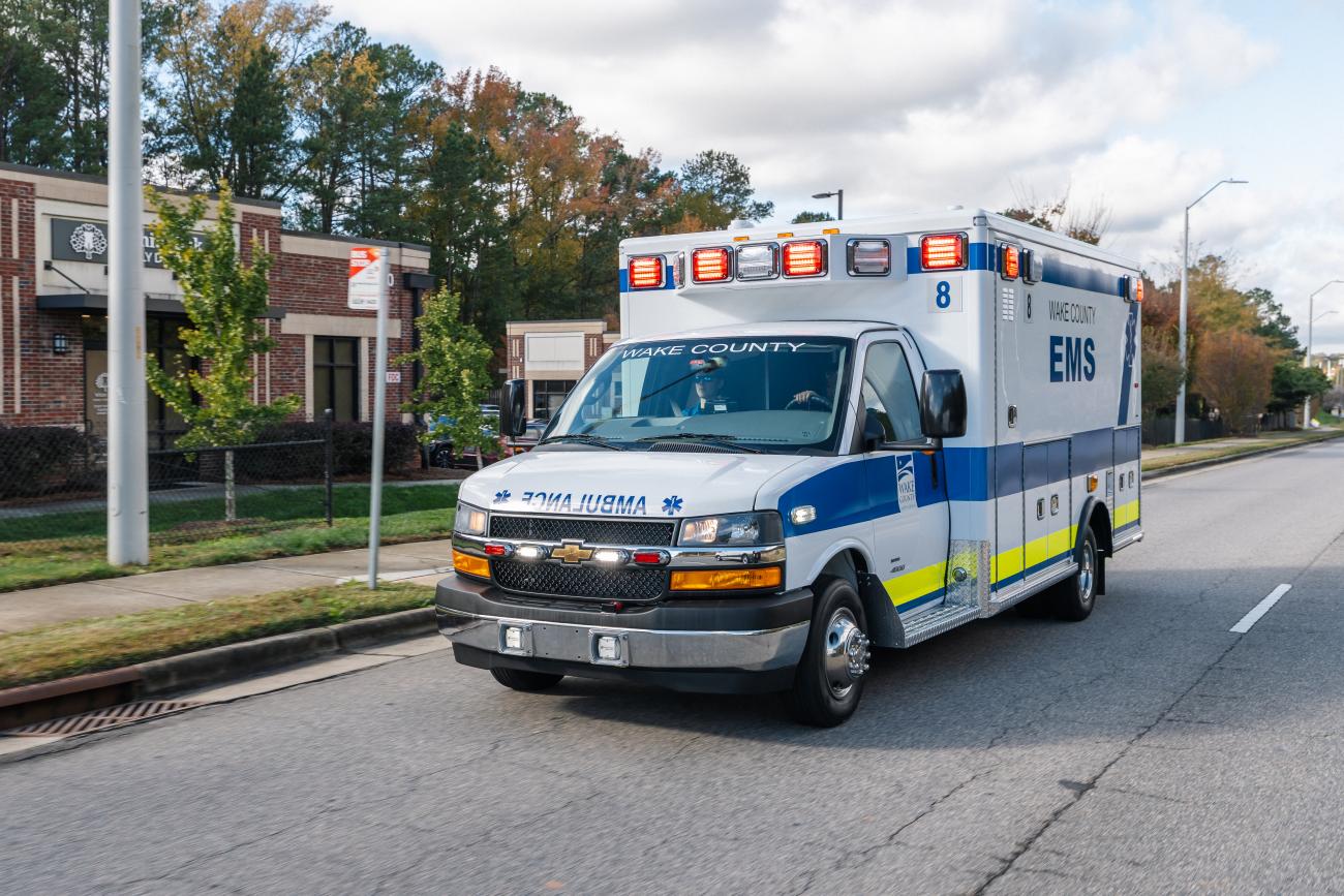 A Wake County EMS ambulance drives down a city street.