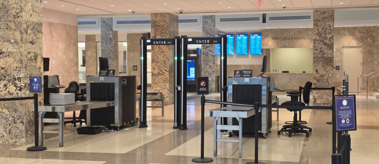 Security screening area inside a Wake County building with metal detectors and x-ray equipment.
