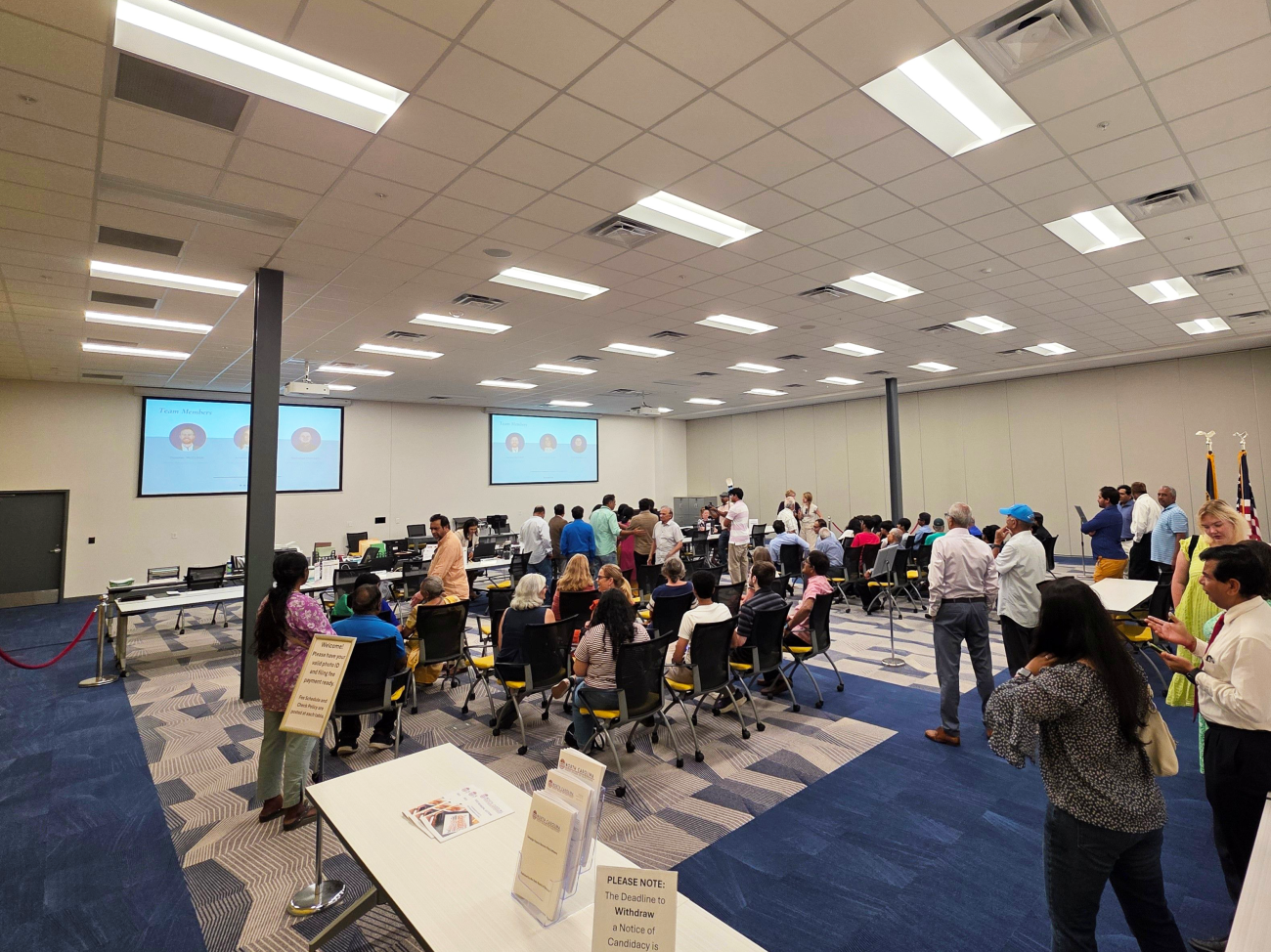People gathered in a room at a presentation and signup.