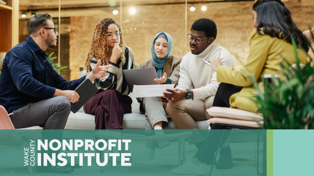 A diverse group of people collaborates around a laptop during a meeting. A banner at the bottom reads, “Wake County Nonprofit Institute.”