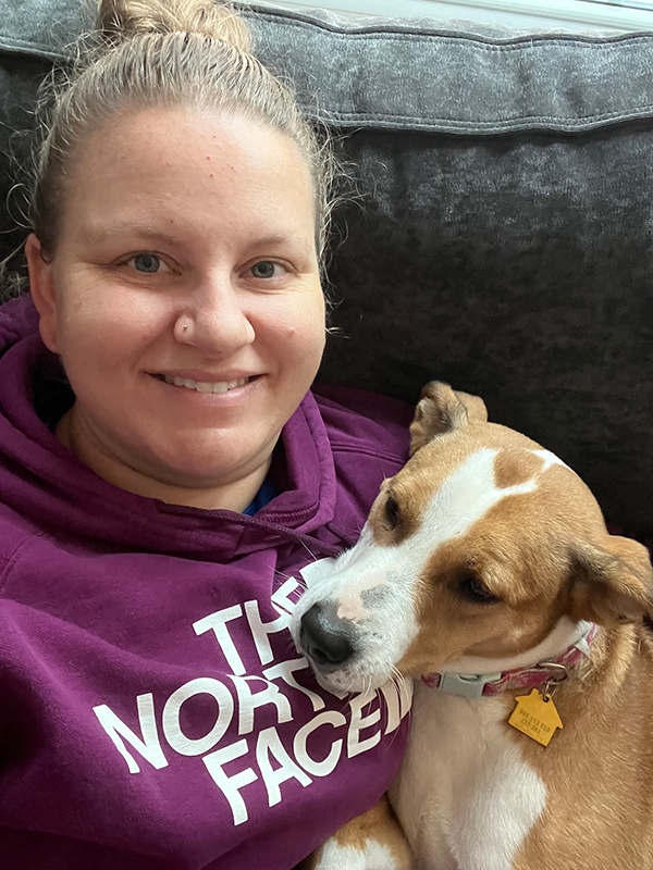 Justine Henderson cuddles with Mae on a couch.