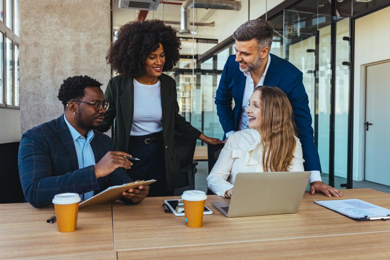Group of employees smiling and working together in a conference room
