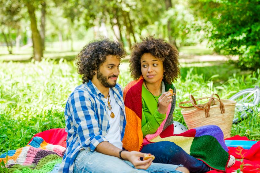 A couple sitting in the park on a picnic date