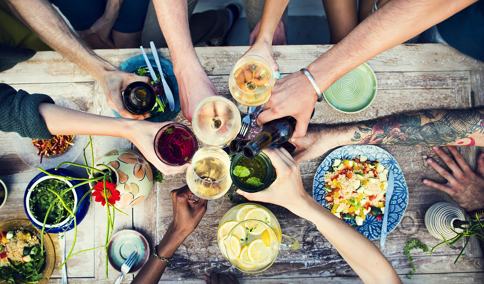 friends-toasting-over-vegan-food-over-picnic-table